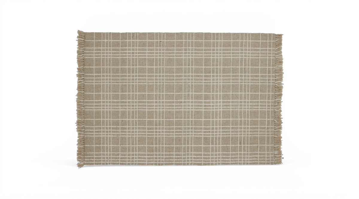 Beige tæppe med hvidt ternet mønster og frynser på kortsiderne, frilagt.