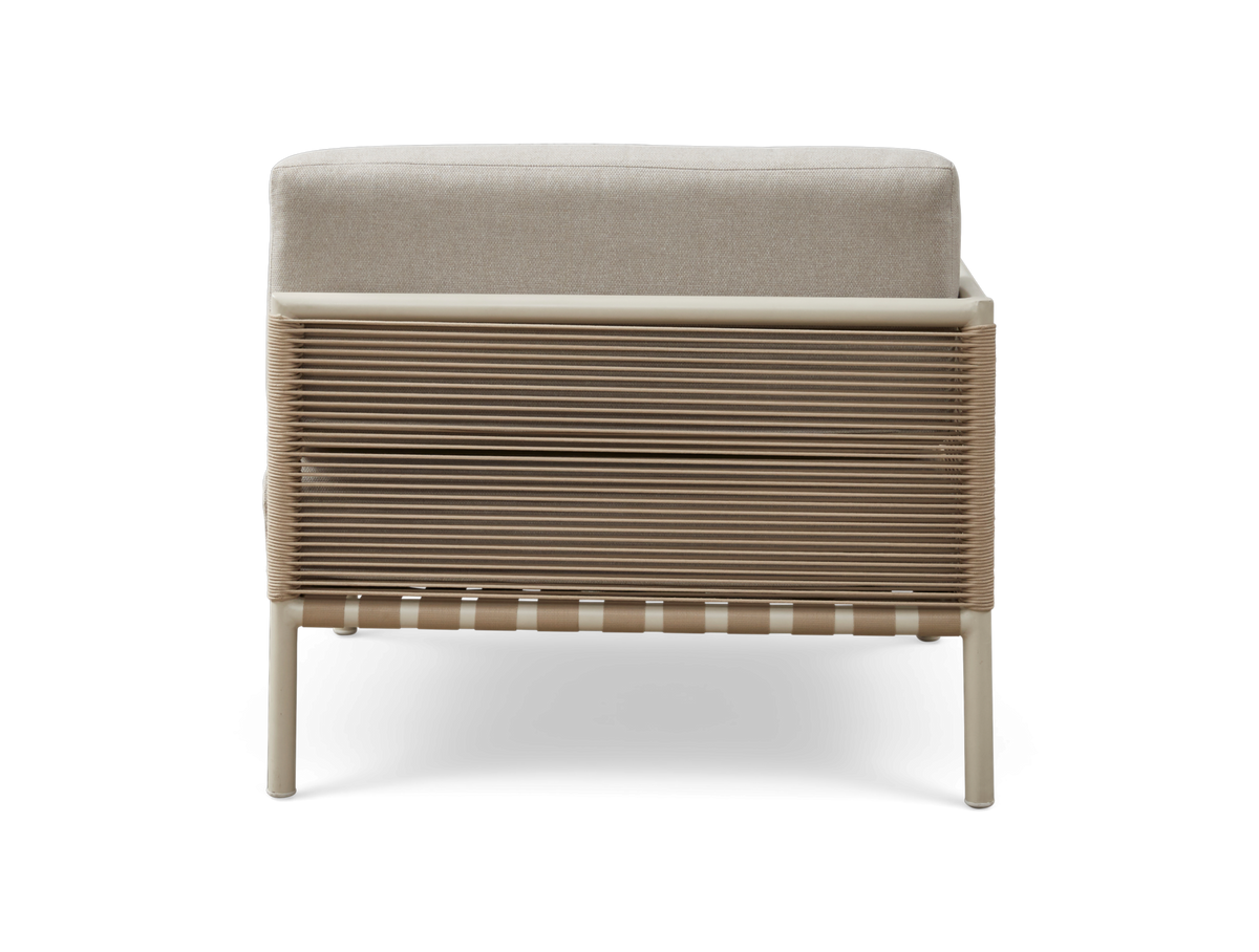 Bagfra af beige loungestol med flettet rebside og lys hynde, frilagt på hvid baggrund.
