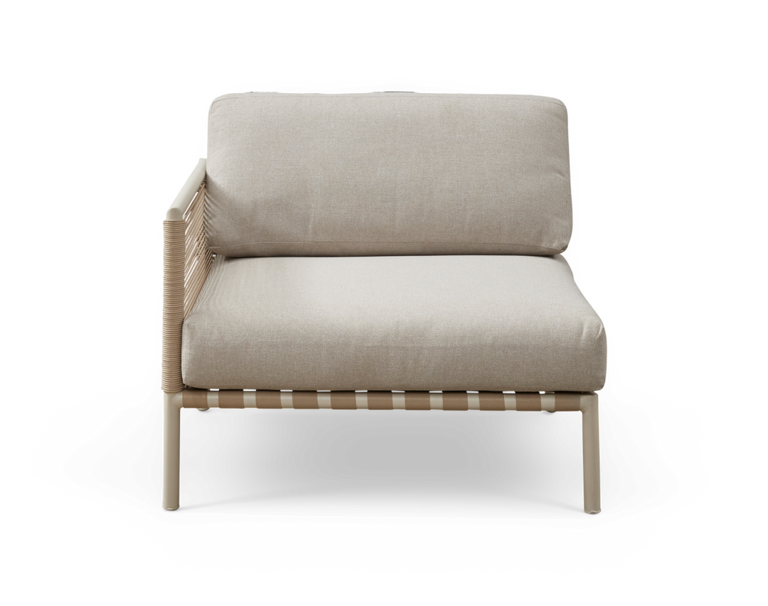 Beige modulsofa med venstre armlæn, flettet side og lyse metalben, frilagt på hvid baggrund.