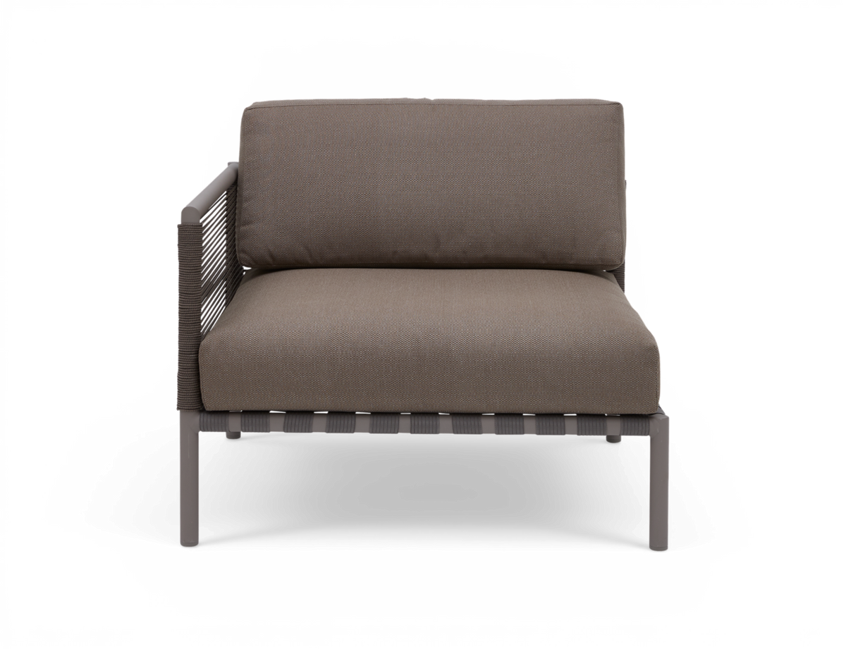 Forfra af taupefarvet udendørs loungestol med venstre armlæn, flettet side og slanke metalben.