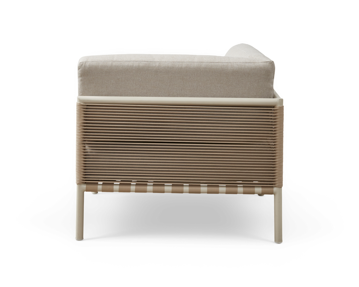 Beige loungestol med snordetaljer på siden og lys hynde, sidevisning frilagt.