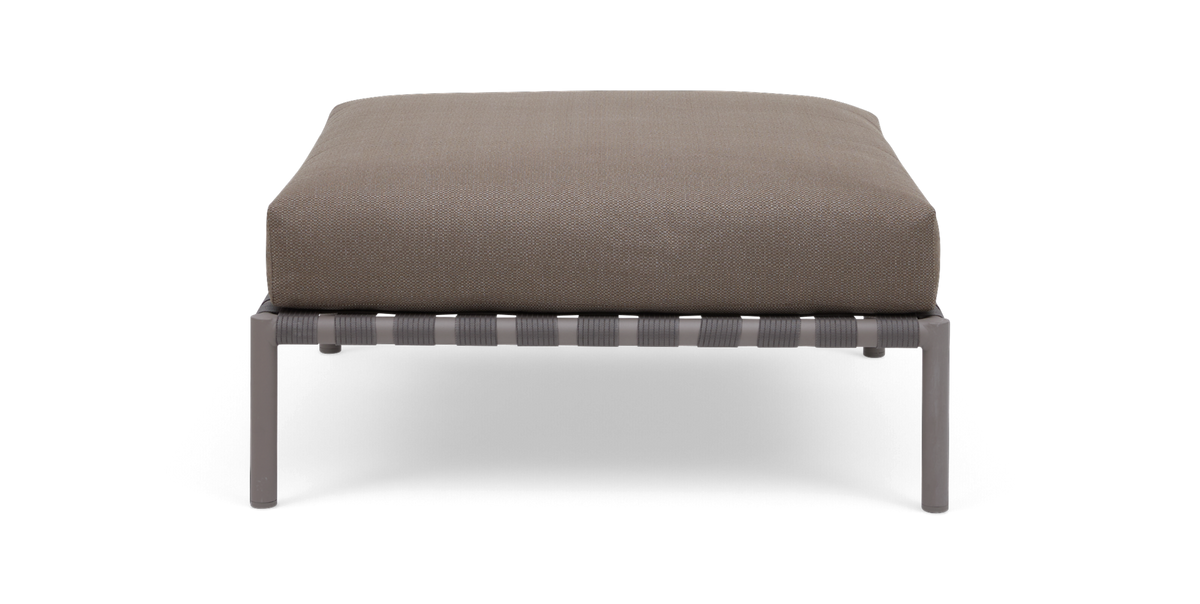Beige fodskammel med rektangulær pude på gråt metalstel, set forfra.