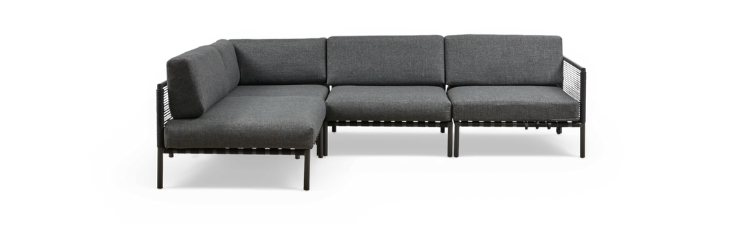 Grå modulopbygget hjørnesofa i stof med metalben, frilagt på sort baggrund.