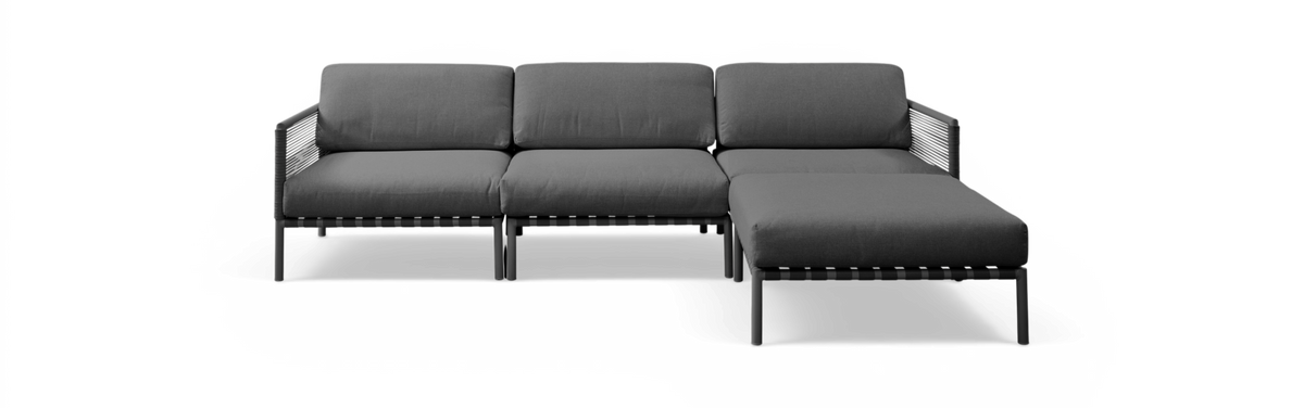 Mørkegrå modulsofa med chaiselong i højre side, fritlagt på sort baggrund i frontvisning.