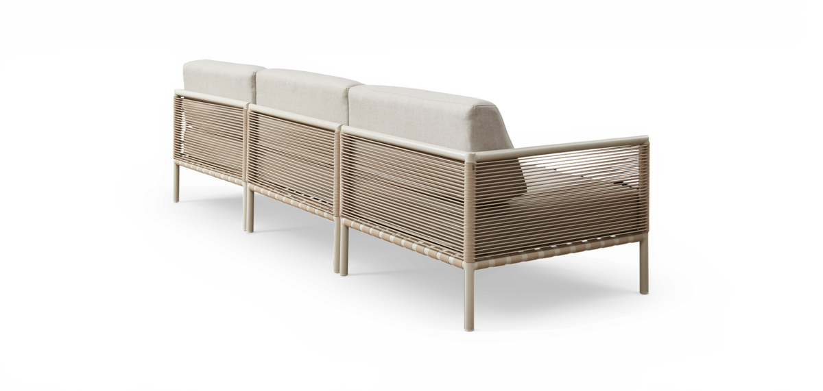 Beige tresæders modulsofa med snoreomviklet stel og lyse hynder, set bagfra i studiemiljø.