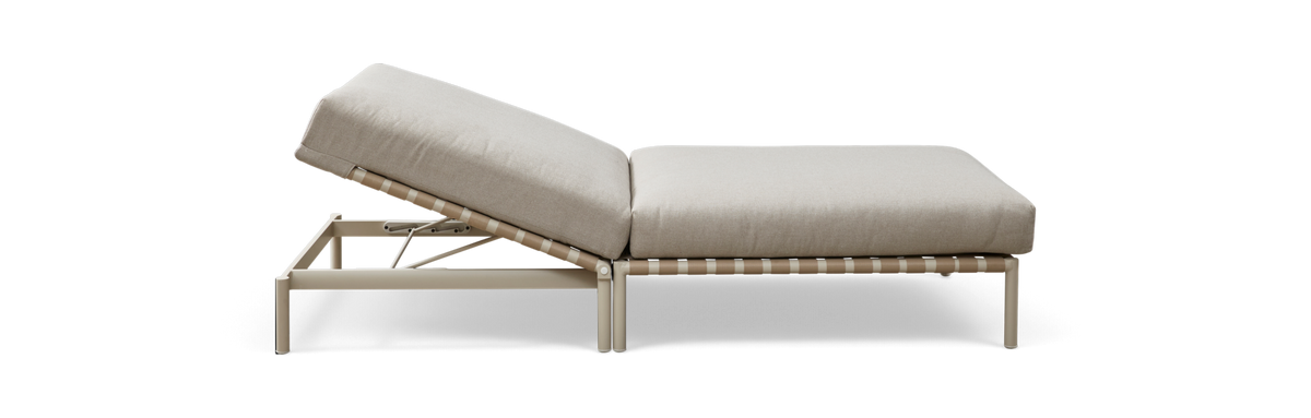 Sideview af en justerbar solseng med beige hynder på lys metalramme, fritlagt mod sort baggrund.