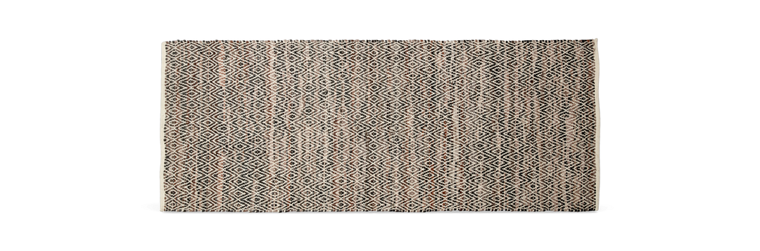 Mønstret tæppe i beige, sort og brune nuancer med geometrisk diamantmønster.