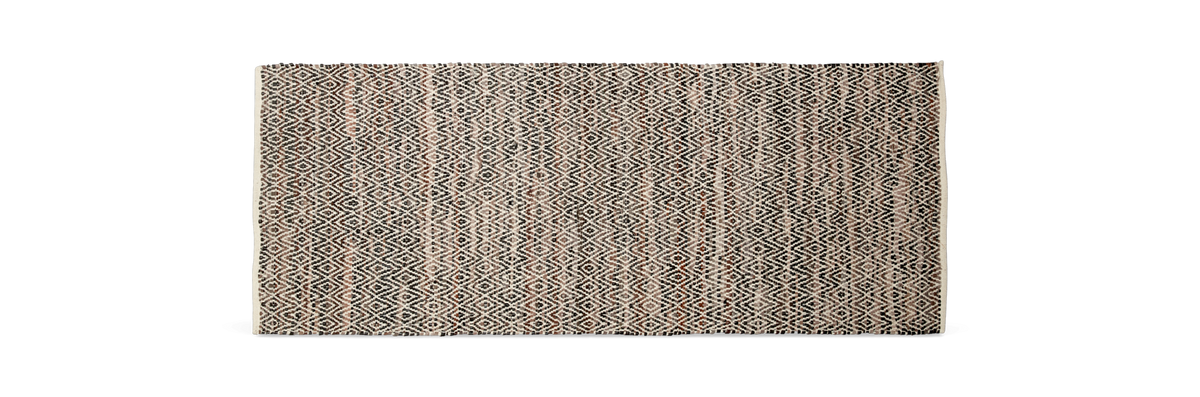 Mønstret tæppe i beige, sort og brune nuancer med geometrisk diamantmønster.