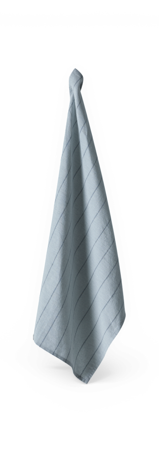 Lyseblåt håndklæde med tynde diagonale striber, hængende mod sort baggrund.