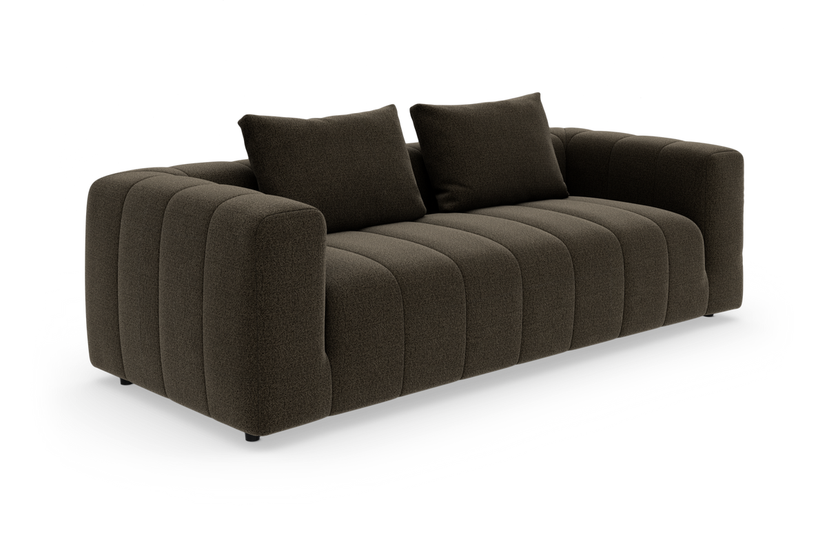 Mørkebrun, kanalquiltet 3-personers sofa med to løse ryghynder, set i trekvart vinkel på hvid baggrund.
