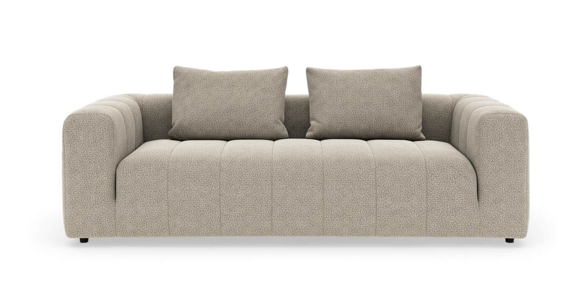 Beige 3-personers sofa med to rygpuder, afrundede armlæn og kanalsyede sæder.