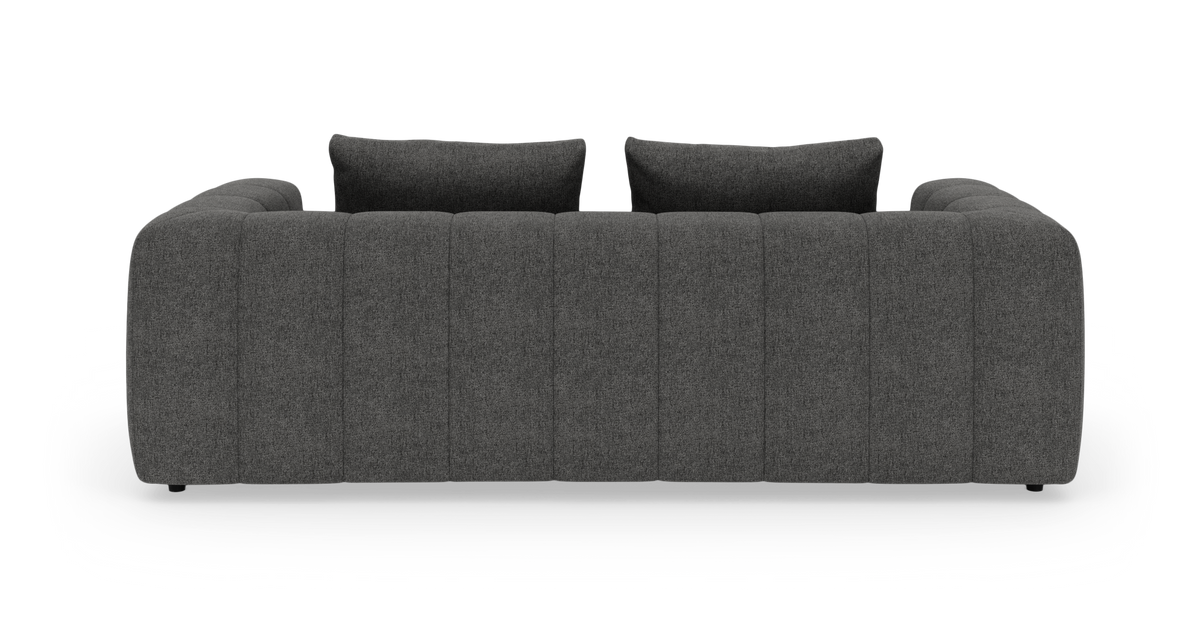 Mørkegrå kanalquiltet 3-personers sofa med to ryghynder set lige forfra på hvid studiebaggrund.