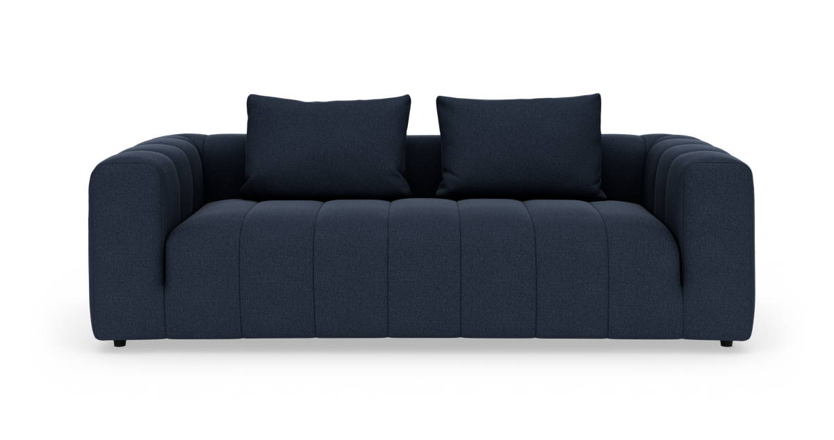 Mørkeblå tresæders sofa med to ryghynder, fotograferet forfra mod hvid baggrund.