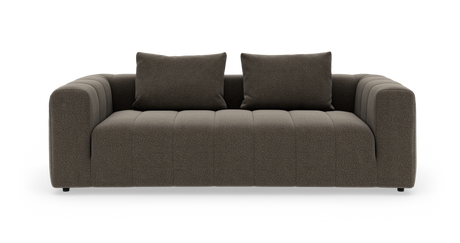 Brun stofsofa med to løse rygpuder og brede, afrundede armlæn, frilagt mod hvid baggrund set forfra.