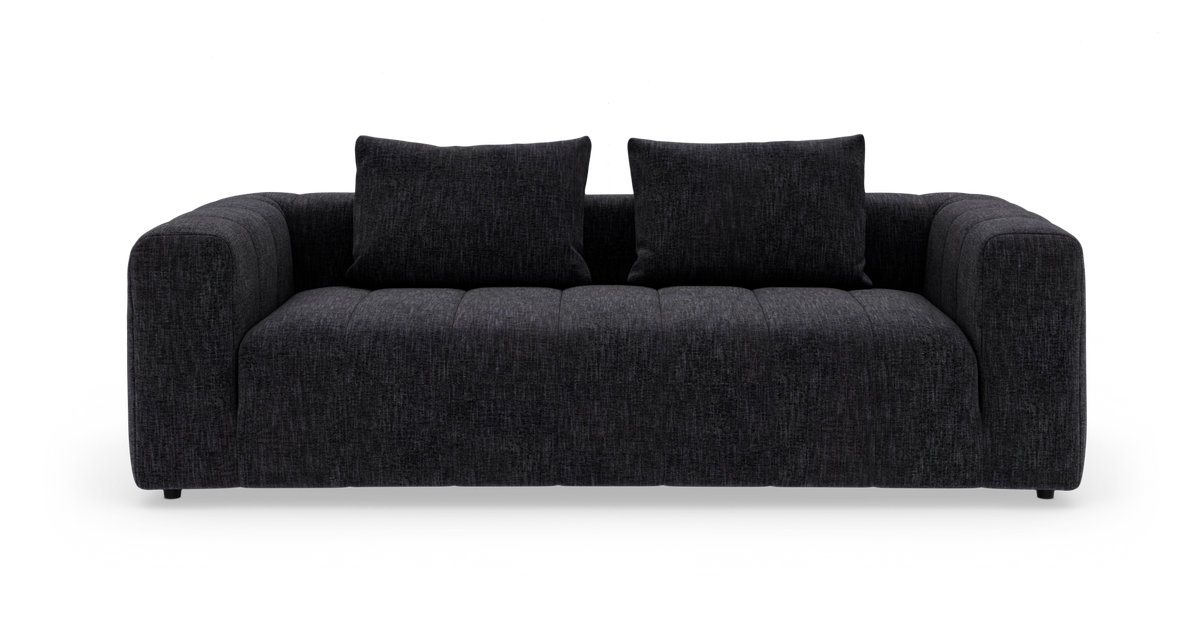 Mørkegrå stofsofa med to ryghynder og brede afrundede armlæn, frontvisning.