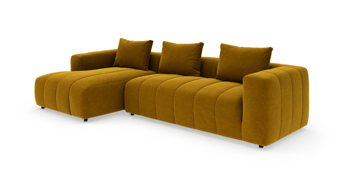 Modulsofa i sennepsgul tekstil med venstrevendt chaiselong og tre rygpuder.