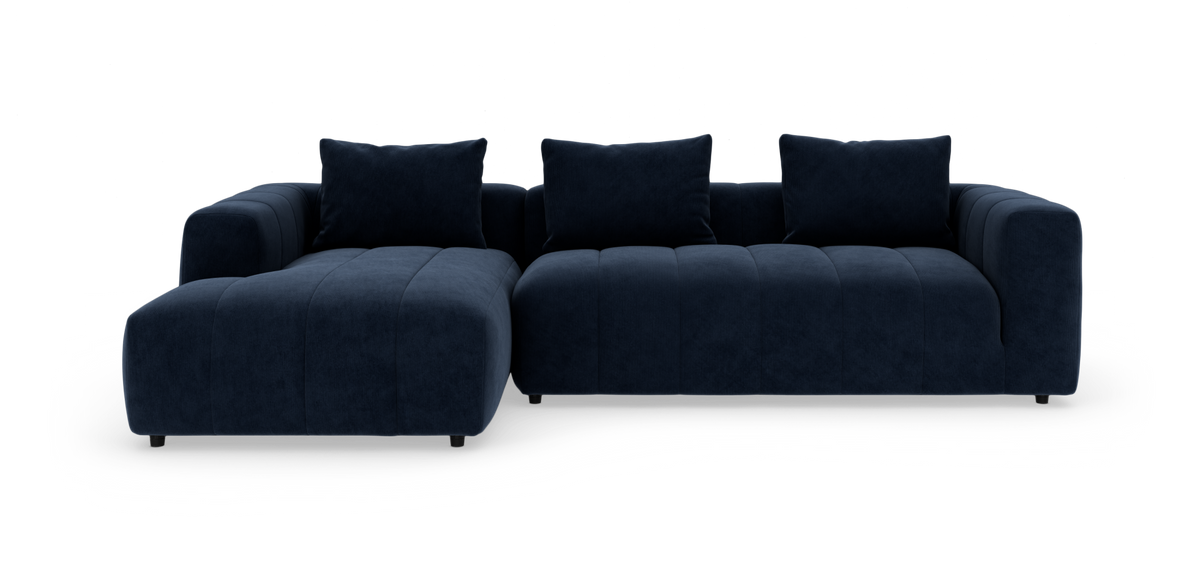 Mørkeblå modulsofa med chaiselong, tre rygpuder og afrundede armlæn på hvid baggrund.