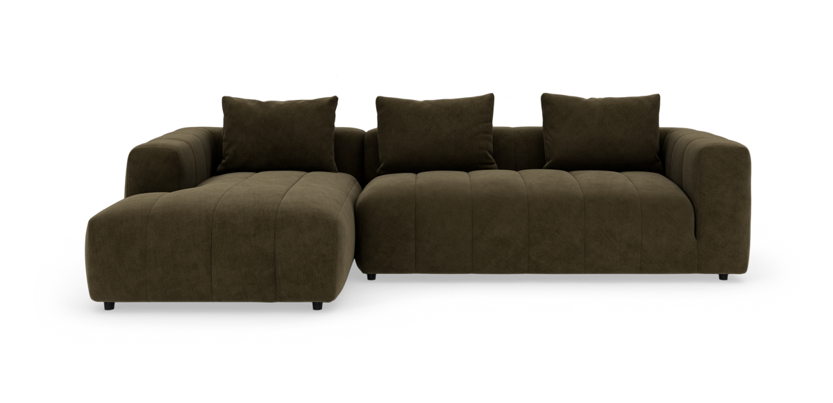 Mørkebrun modulsofa med bred chaiselong til venstre og tre store ryghynder, fotograferet lige for mod hvid baggrund.
