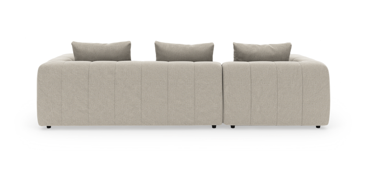 Beige modulsofa set lige bagfra med tre rygpuder, fritstående på hvid baggrund.