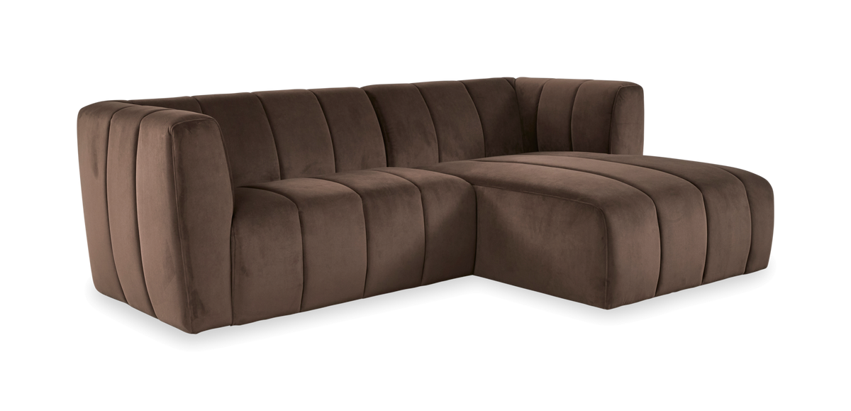 Brun modul-sofa i fløjl med rundede former og vertikale kanaler, vist i vinkel på hvid baggrund.