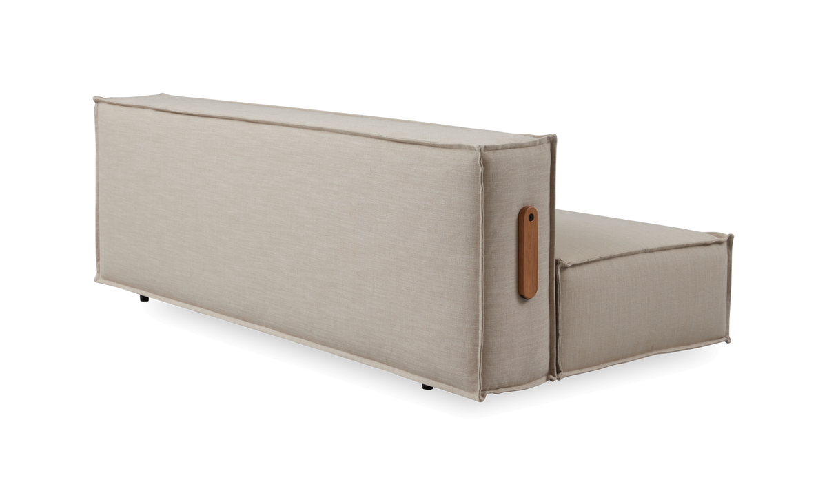 Beige modulsofa med høj ryg og træhåndtag på siden, frilagt på hvid baggrund.