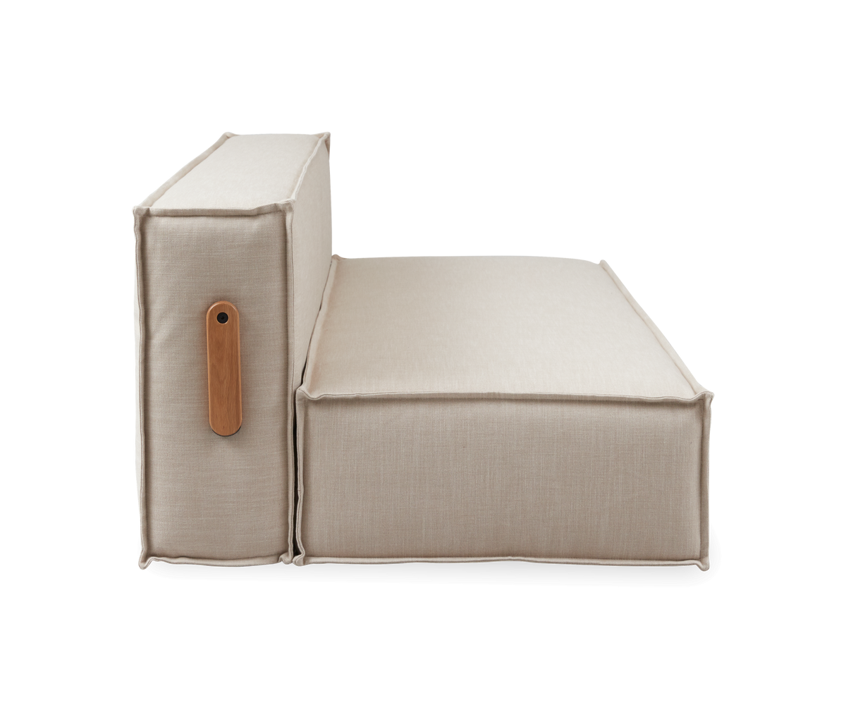 Sidevisning af beige modulsofa med sæde og ryglæn, markante syninger og træhåndtag, fritlagt på hvid baggrund.