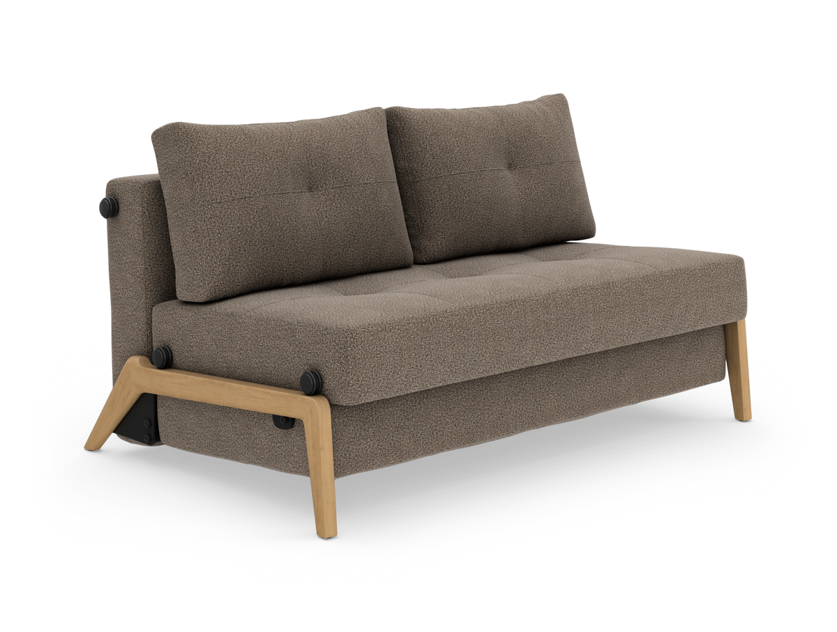 Kompakt 2-personers sofa i beige/brun tekstil med træramme og -ben, to ryghynder og tuftet sæde, fotograferet i studie, set skråt forfra.
