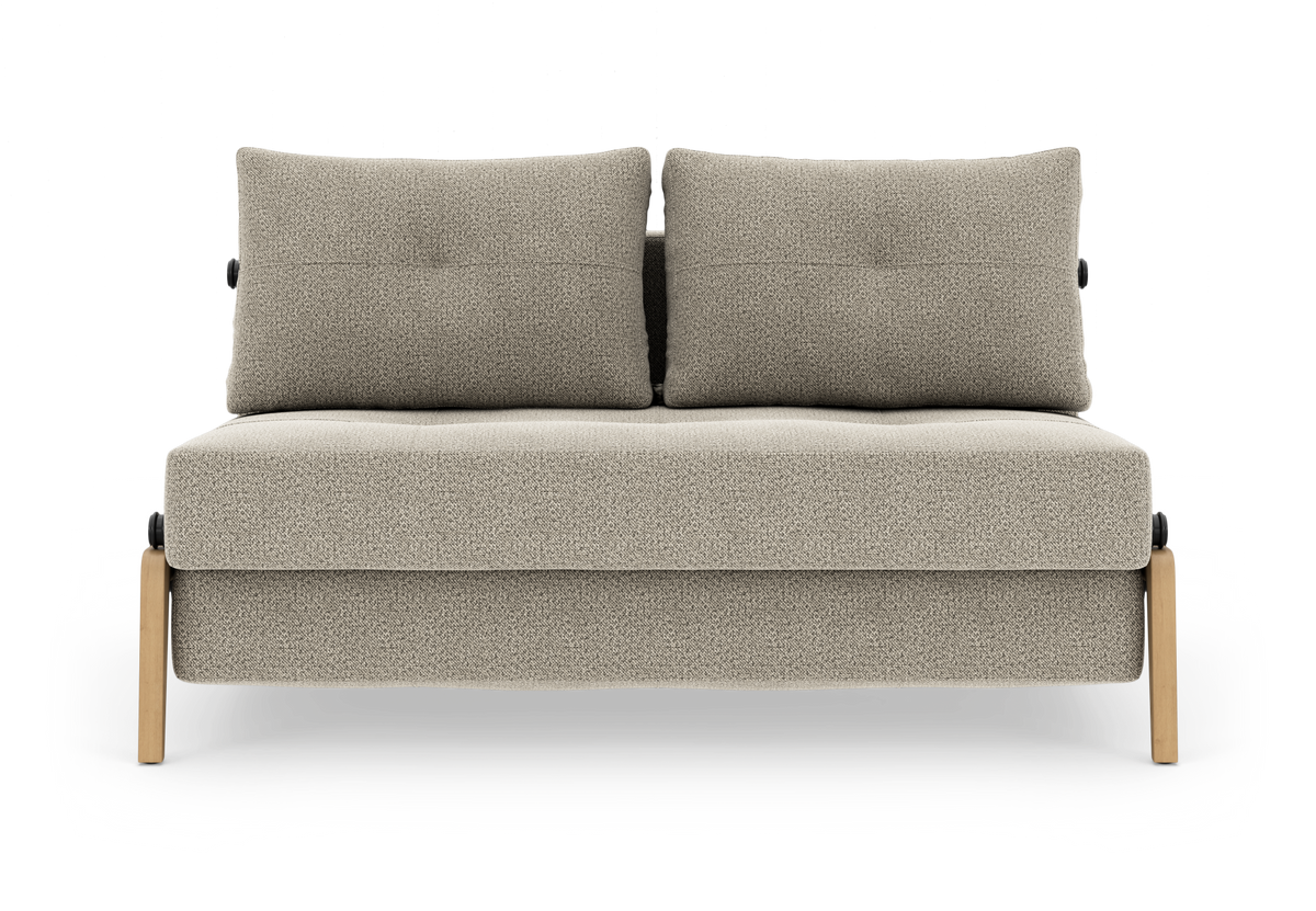 Beigefarvet to-personers sofa med to ryghynder og lyse træben, frilagt på hvid baggrund.