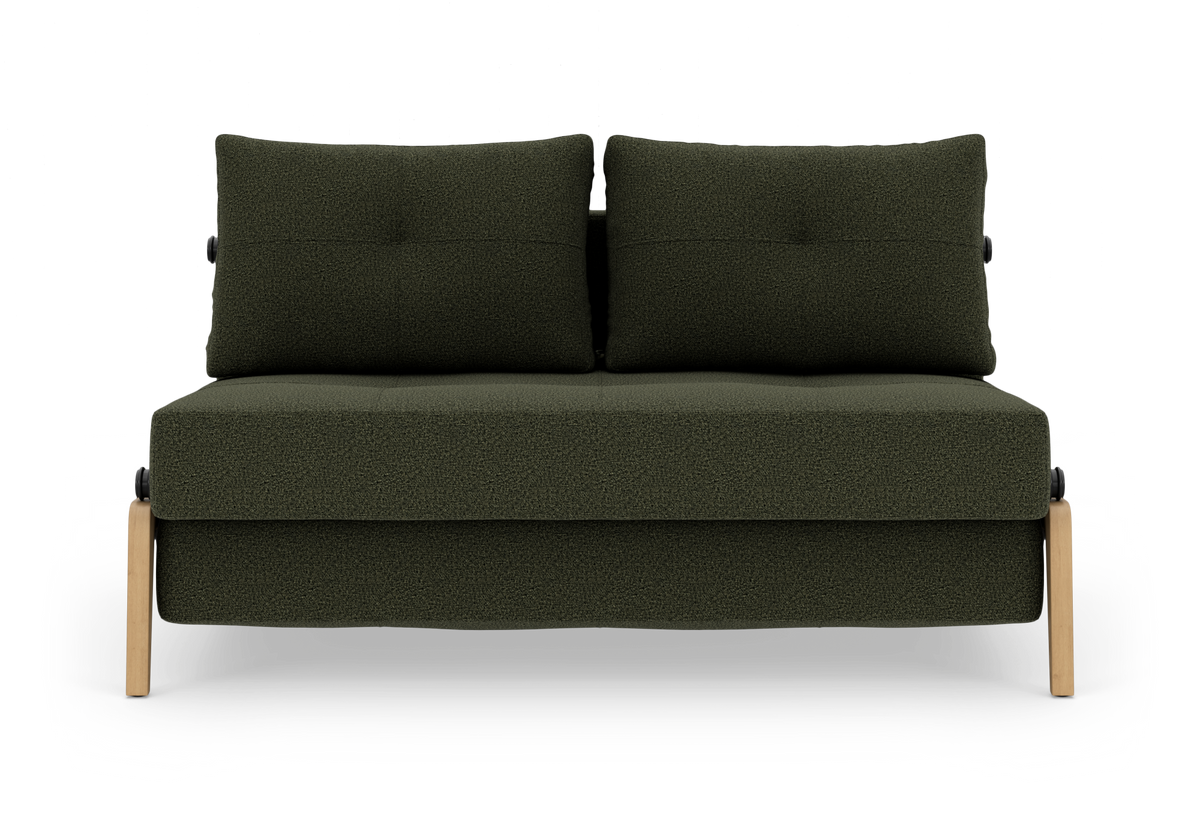 Mørkegrøn 2-personers sofa med to rygpuder og lyse træben, frilagt på hvid baggrund.