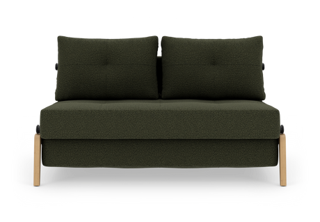 Mørkegrøn 2-personers sofa med to rygpuder og lyse træben, frilagt på hvid baggrund.