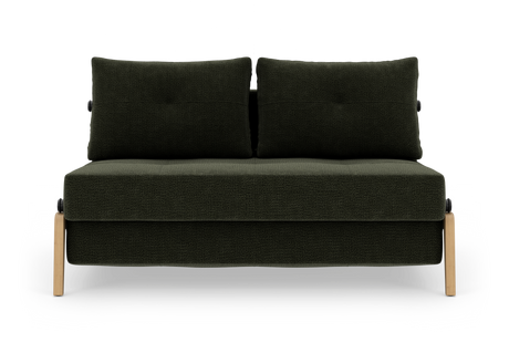 Mørkegrøn to-sæders sofa med to ryghynder og lyse træben, frilagt på hvid baggrund.