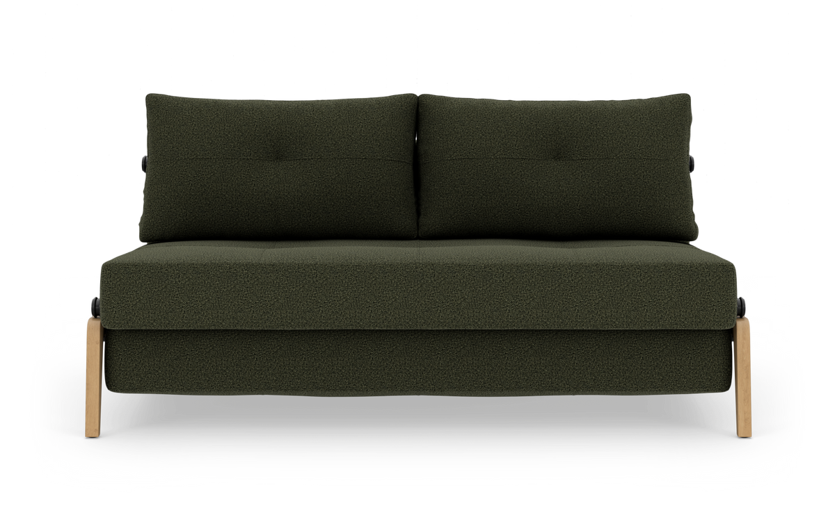 Grøn to-personers sofa i mørkegrønt stof med to rygpuder og lyse træben, fotograferet forfra mod hvid baggrund.