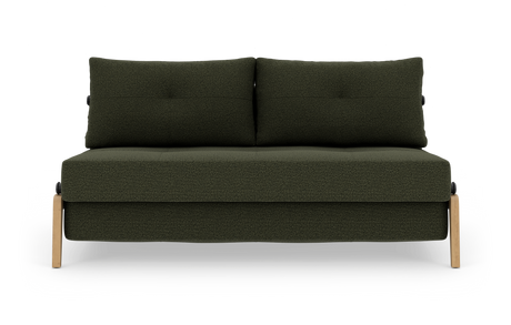 Grøn to-personers sofa i mørkegrønt stof med to rygpuder og lyse træben, fotograferet forfra mod hvid baggrund.