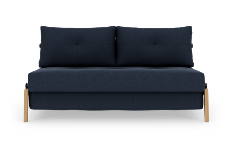 Mørkeblå tosædet sofa med to ryghynder og lyse træben, fotograferet lige forfra mod hvid baggrund.