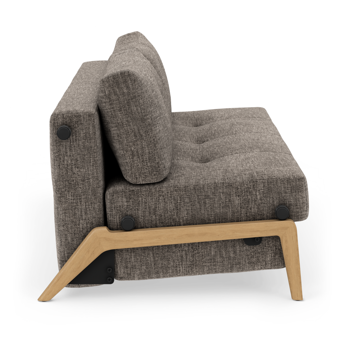 Grå stofsofa set fra siden med træramme og ben, frilagt på hvid baggrund.
