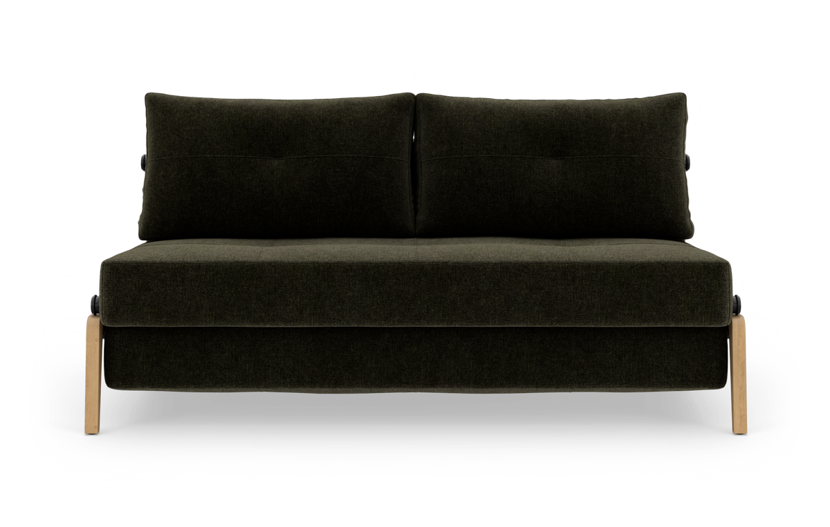 Mørkegrøn tosædet sofa med to ryghynder og lyse træben, fotograferet forfra på hvid baggrund.