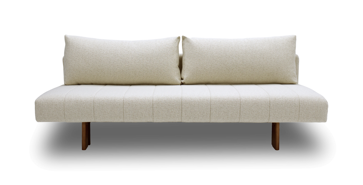 Beige 2-pers. sofa med to store rygpuder og træben, frilagt mod hvid baggrund.