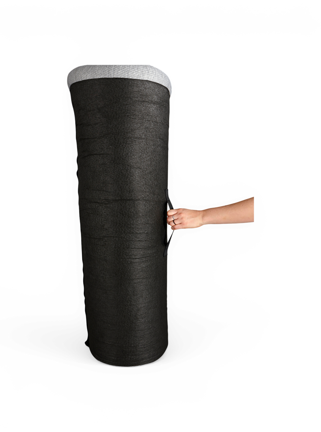 Stor sort cylindrisk stofpotte/dyrkningspose med grå kant og bærehåndtag, holdes i siden af en hånd, frilagt på hvid baggrund.