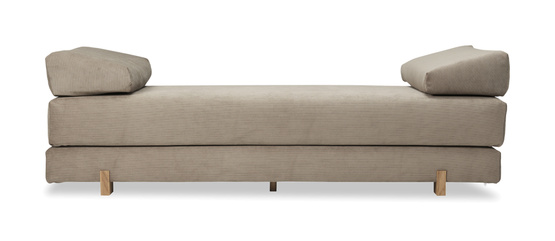 Beige daybed i fløjl med to kileformede puder og træben.