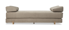 Beige daybed i fløjl med to kileformede puder og træben.
