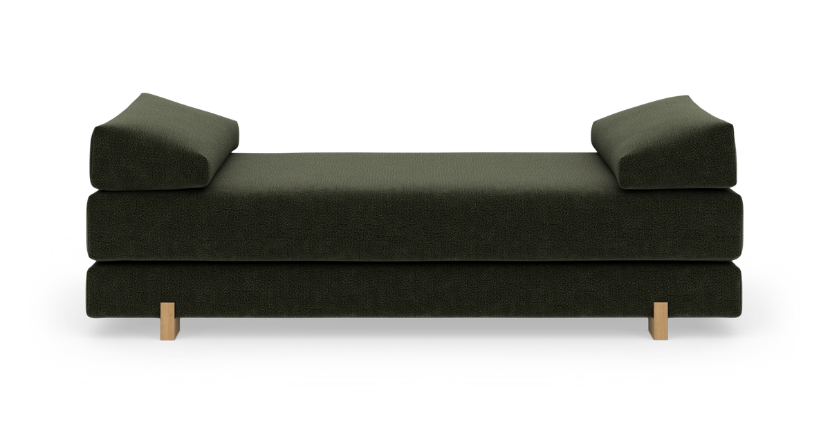 Mørkegrøn daybed med korte træben, fotograferet lige forfra på hvid studiebaggrund.