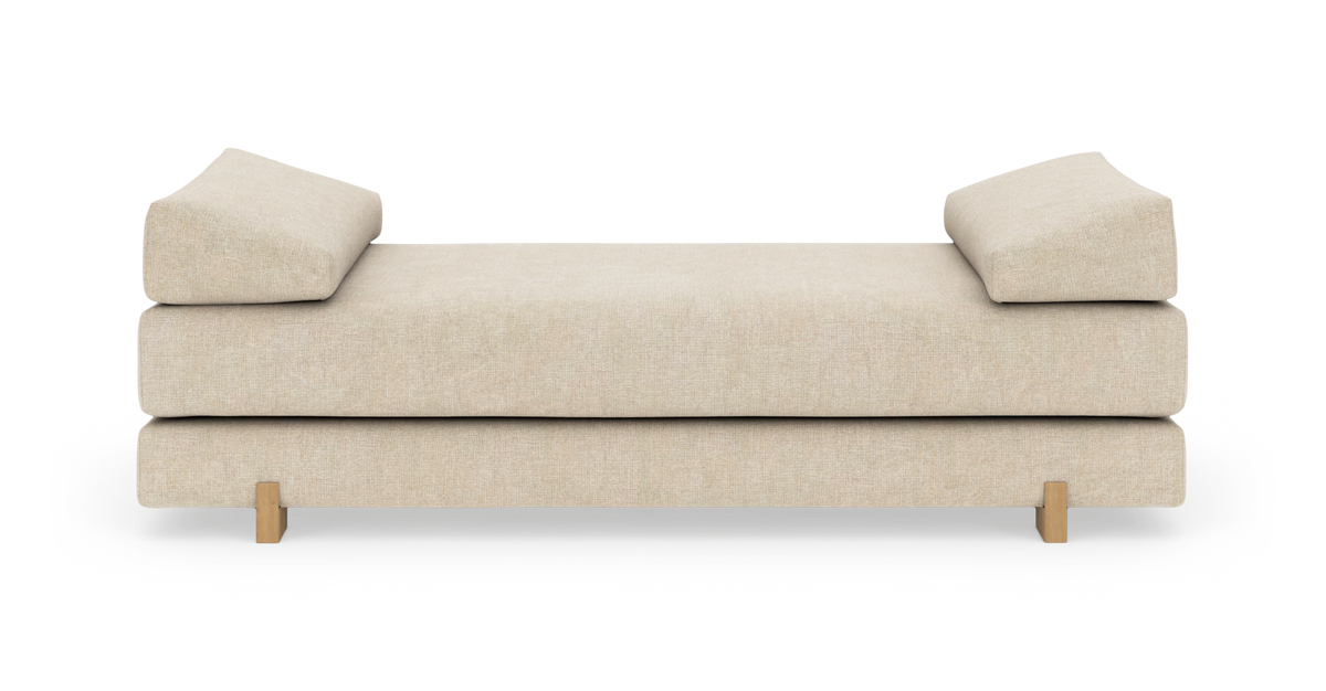 Beige daybed/sofa med to vinklede puder og træben, frilagt frontvisning på hvid baggrund.