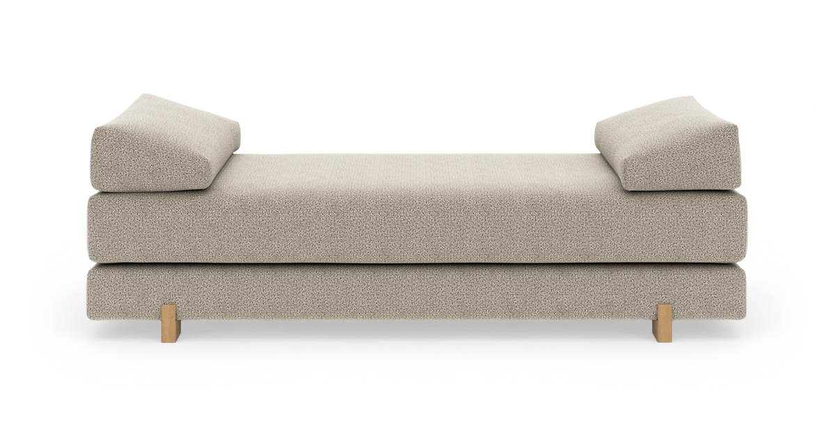 Beige daybed med skrå armlæn og træben, frilagt på hvid baggrund.