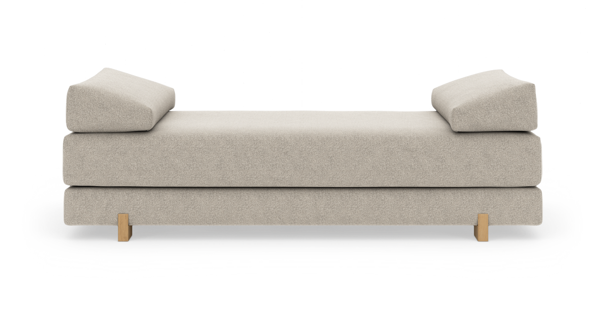 Beige daybed med vinklede armlæn og træben, frilagt på hvid baggrund.