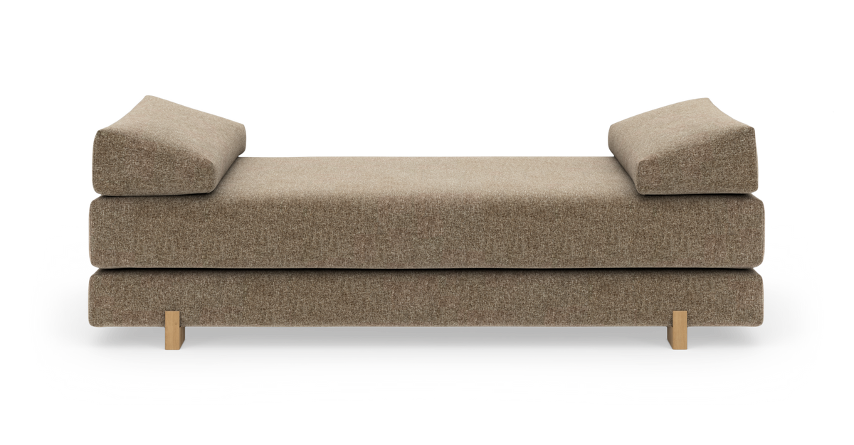 Beige daybed med kileformede armlæn og træben, frilagt på hvid baggrund.