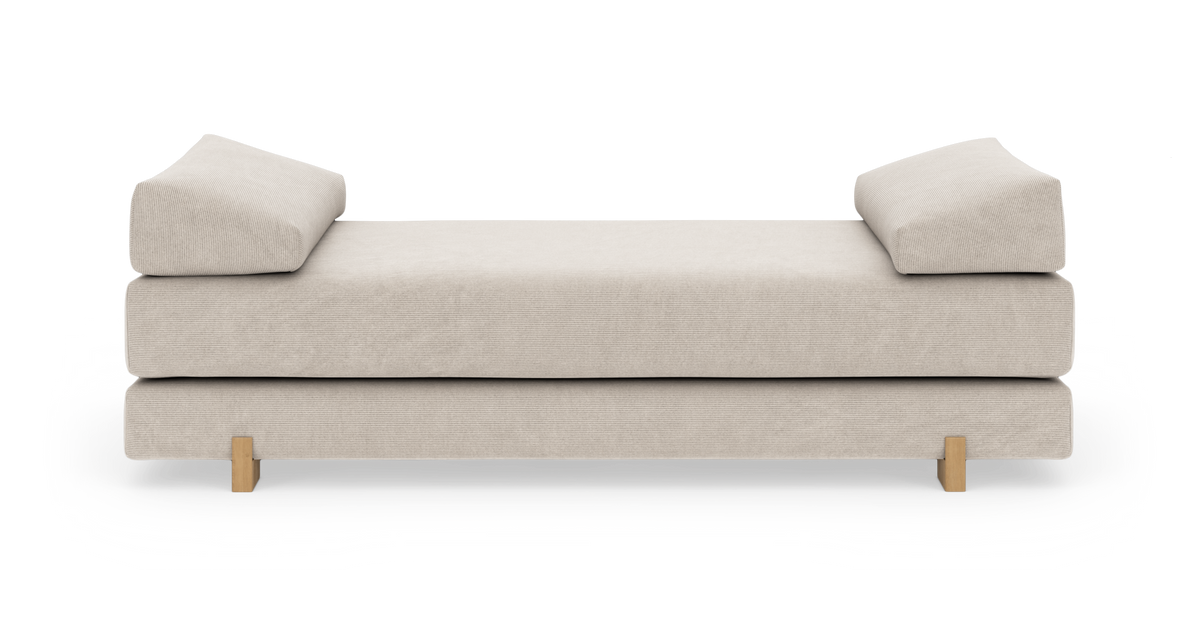 Beige daybed/sofa med to kileformede armlæn og træben, fritlagt på hvid baggrund.