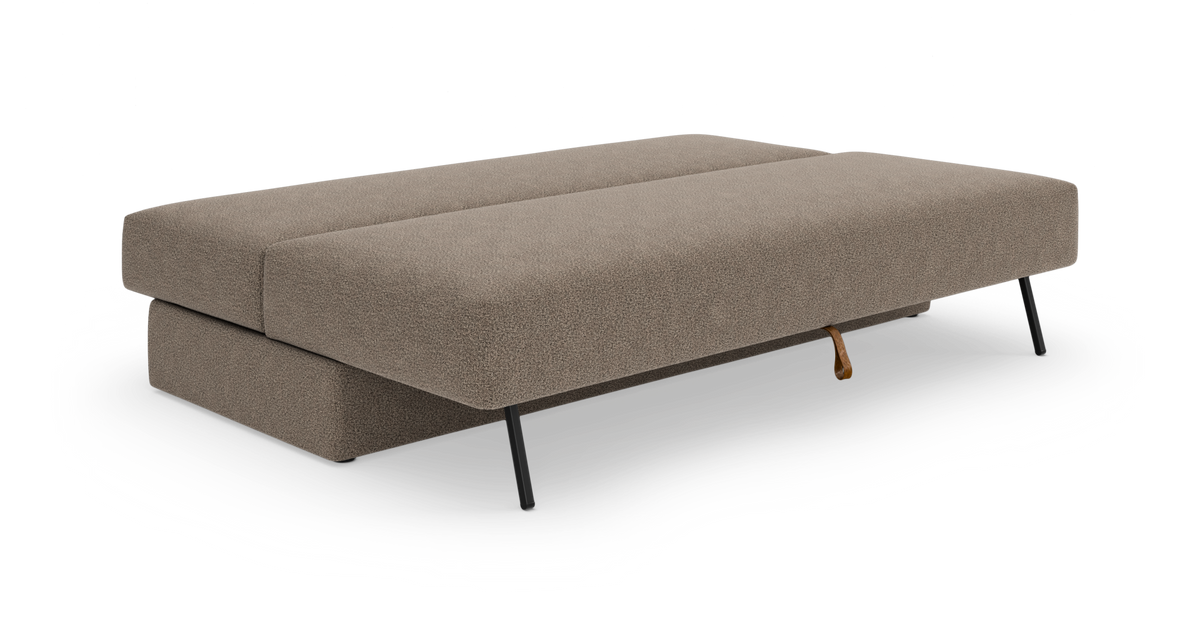 Beige sovesofa i udslået position med slanke sorte metalben, fritlagt på hvid baggrund.