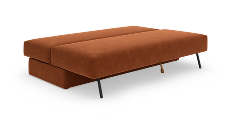 Rustrød sovesofa i stof, udslået til sengeleje med sorte metalben, frilagt på hvid baggrund.