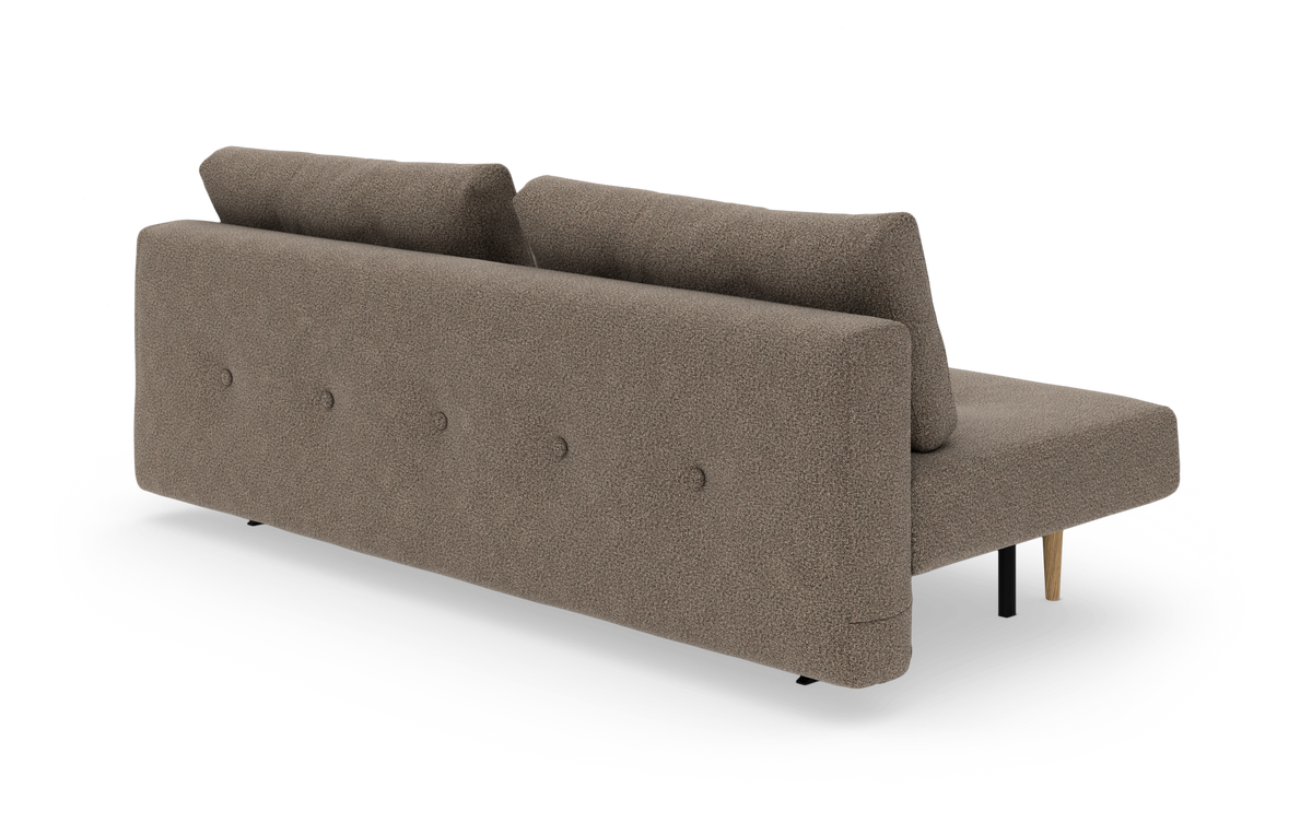 Brun/beige bouclésofa med chaiselong til højre, knapdetaljer på ryg og mix af sorte og træben, frilagt på hvid baggrund.