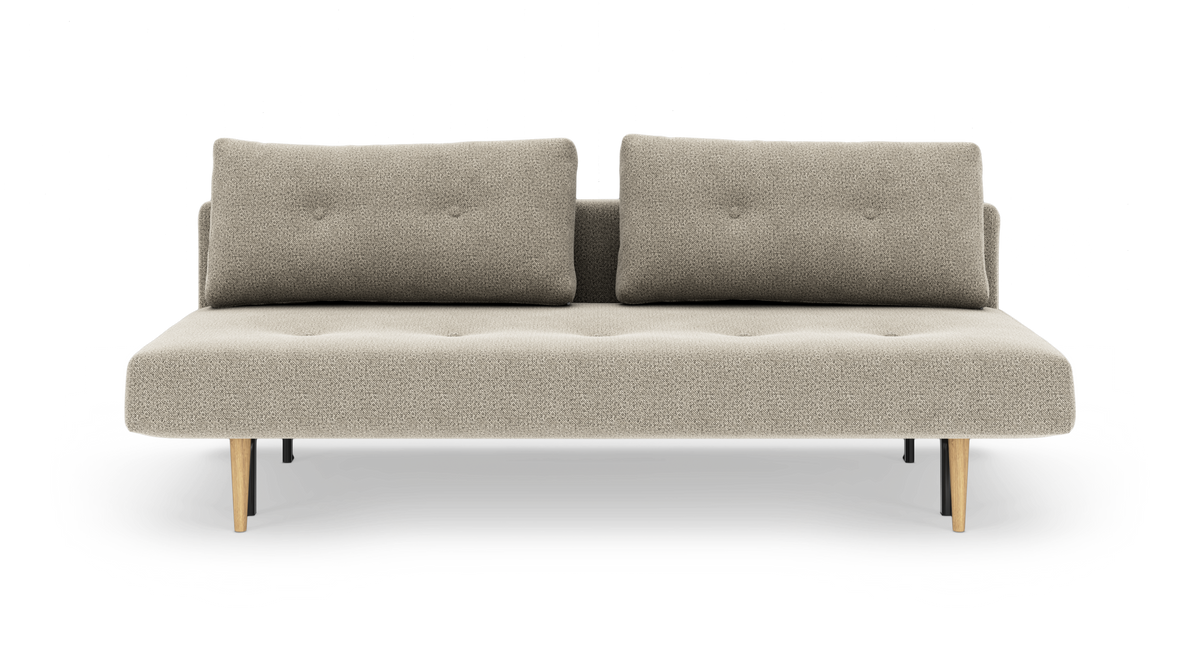 Beigefarvet sofa med to rygpuder og koniske træben, frilagt på hvid baggrund.